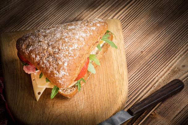 Triangular sandwich with cheese, ham and tomato. - Photo, image