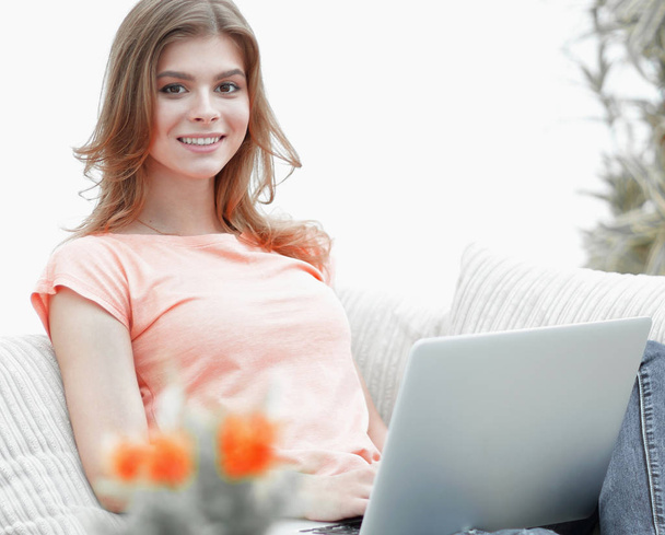 beautiful girl with a laptop sitting on the couch. - Foto, Imagem