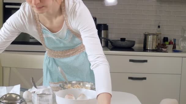 Cute woman baking in her kitchen - Filmati, video