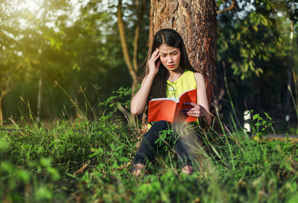woman in stress situation when reading a book in the park - Foto, Imagen