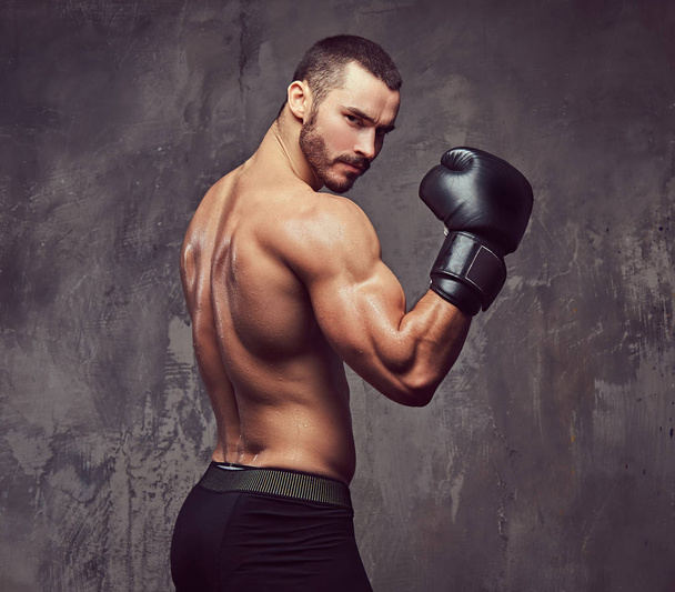 Жорстокий м'язистий боксер з боксерськими рукавичками, що працюють над технікою удару
. - Фото, зображення