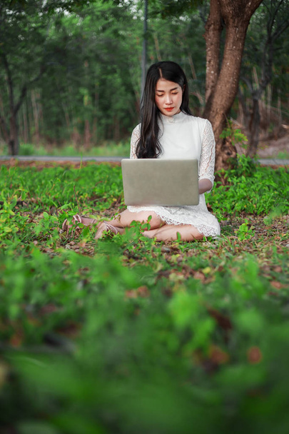 beautiful woman using laptop in the park - Фото, зображення