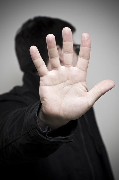 Mysteriöser Mann hält die Hand auf und schaut weg - Foto, Bild