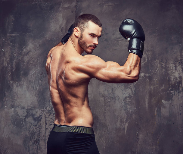 Жорстокий м'язистий боксер з боксерськими рукавичками, що працюють над технікою удару
. - Фото, зображення