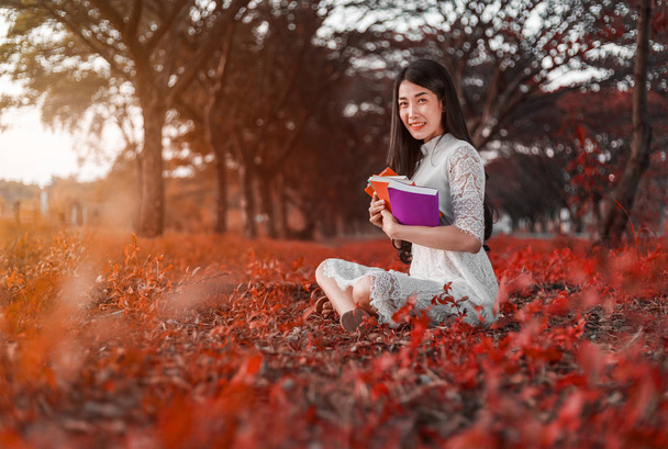 young woman holding a book in park - Foto, immagini