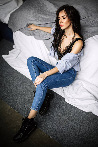 cute young woman sitting on the floor in blue jeans and blue shirt, fashion - Fotó, kép