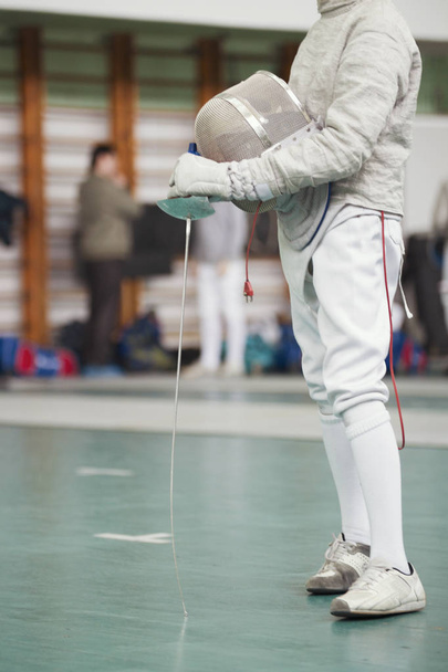 Учасник турніру фехтування з репером і захисною маскою в руках
 - Фото, зображення