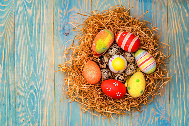 Varios huevos de Pascua de colores en el nido cerca
 - Foto, Imagen