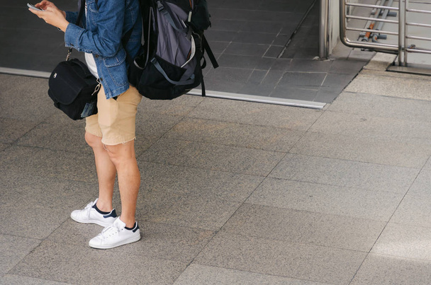 young man backpacker travelling with mobile phone in summer season on street in big city, backpack, photographer, holiday, tourist, travel, lifestyle, fashion and vacation concept - Foto, Imagem