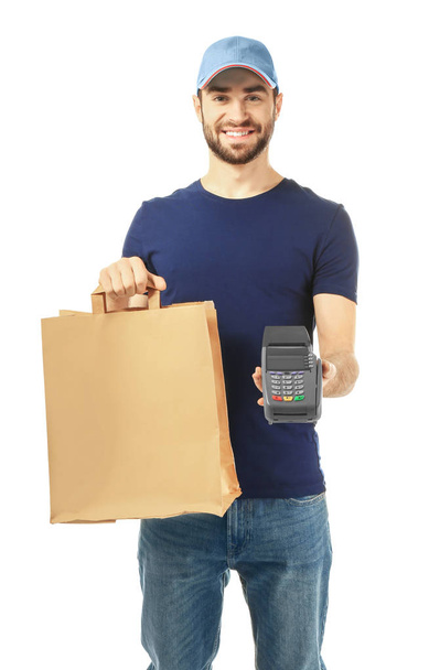 Liefermann hält Papiertüte mit Lebensmitteln und Zahlungsterminal auf weißem Hintergrund - Foto, Bild