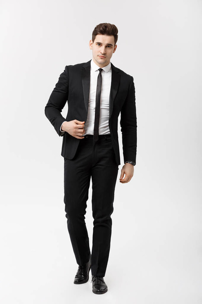 Businessconcept: Full length portret beeld van een elegante zakenman in slimme pak lopen op witte achtergrond. - Foto, afbeelding