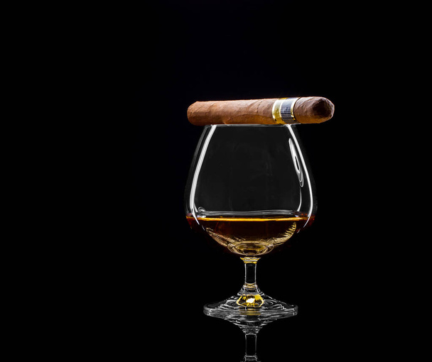Cognac draaibaar met gouden alcohol en sigaar - Foto, afbeelding
