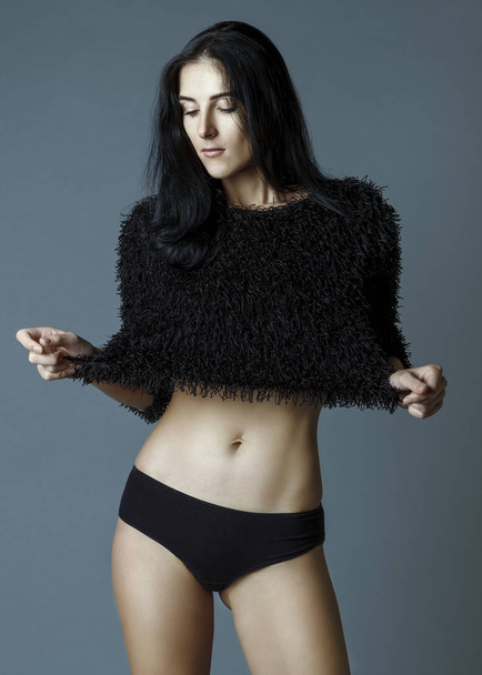 sensual skinny dark hair girl looking down and show off sweater - Photo, Image