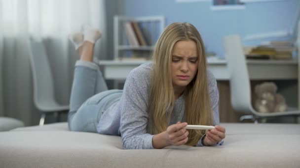 Teen girl sees two strips on pregnancy test, crying, feels desperate and fear - Imágenes, Vídeo