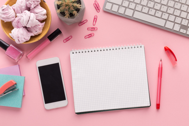 Pracovní prostor s Poznámkový blok a smartphone na růžovém pozadí - Fotografie, Obrázek
