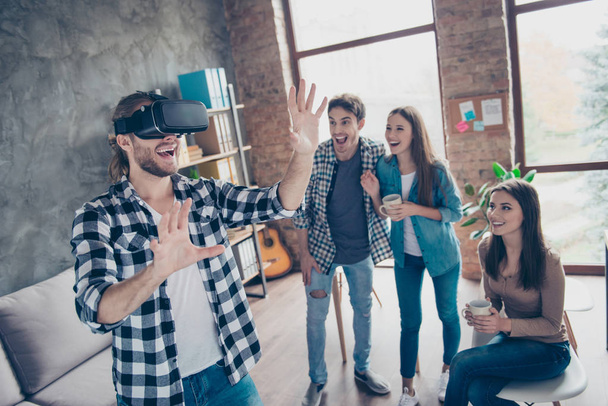 Cheerful guy wearing virtual reality goggles, getting experience - Photo, image