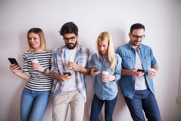 group of young happy coworkers with gadgets having fun at break while drinking coffee - Photo, Image