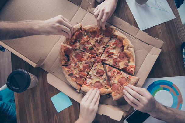 Portrait von Personen, die Pizza in Scheiben schneiden, Gruppe  - Foto, Bild