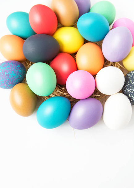 Multi-colored Easter eggs in nest on wooden background, selective focus image. Happy Easter card - Foto, Imagem