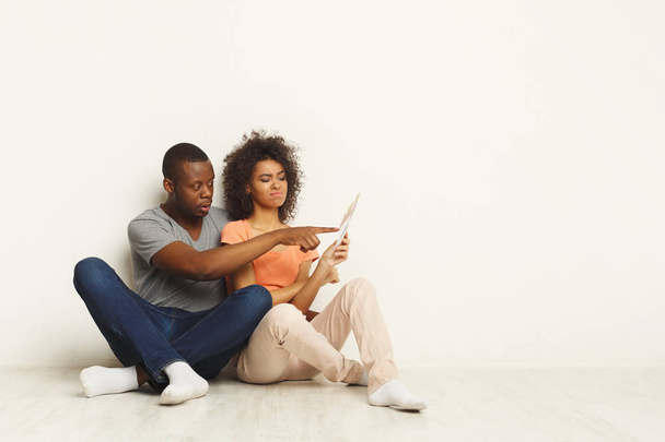 Schwarzes Paar sitzt in neuer Wohnung auf dem Boden - Foto, Bild