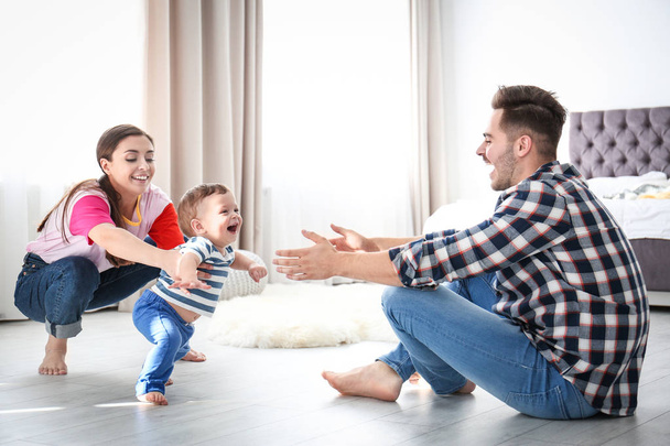Happy family playing and baby learning to walk at home - Foto, Bild