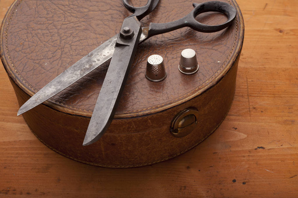 tesouras de costureira no conceito de artesanato caixa de couro na textura de madeira
 - Foto, Imagem