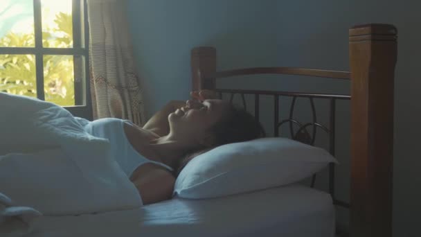 Portrait of just awake young woman lying in bed at home at morning. - Filmati, video