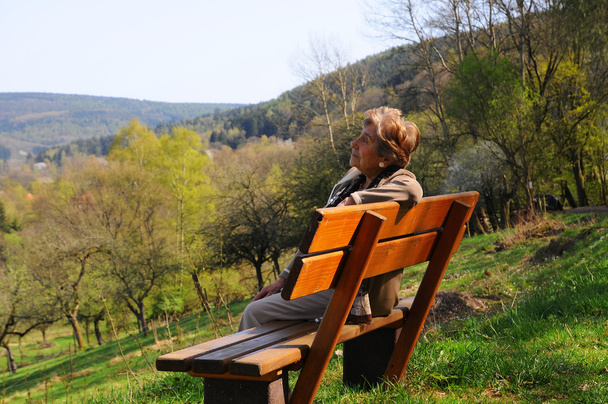 gepensioneerde alleen zittend op parkbank - Foto, afbeelding