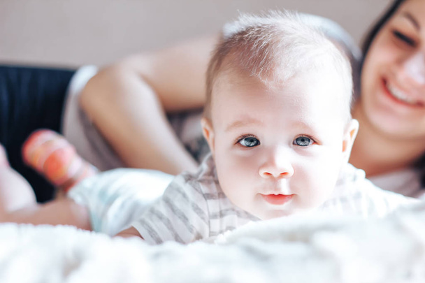 Kleines Baby blickt in Kamera, Mutter unkonzentriert - Foto, Bild