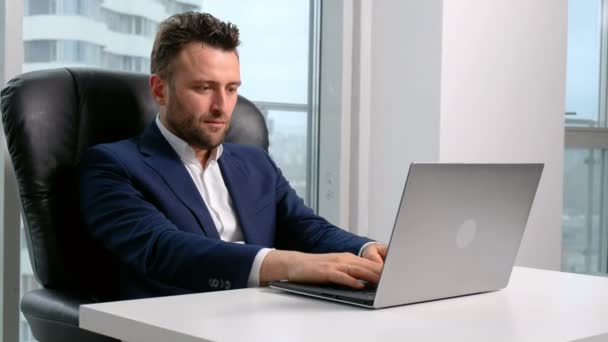 Businessman in formal wear using laptop in office - Felvétel, videó