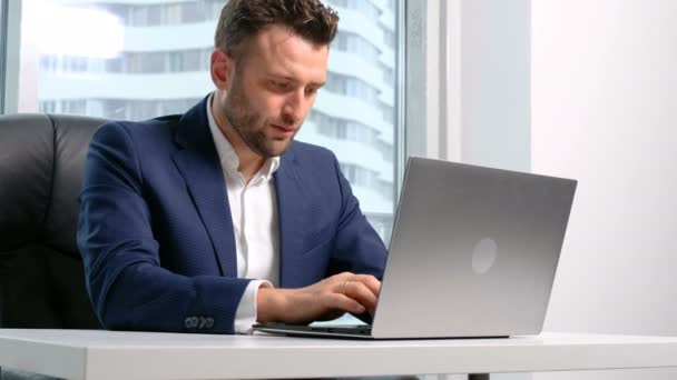 Businessman in formal wear using laptop in office - Video