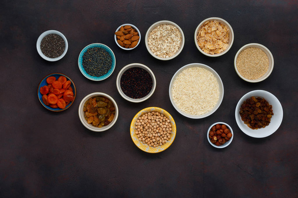 Set of vegetarian healthy food - different superfood, seeds and cereal on dark background. - Photo, image
