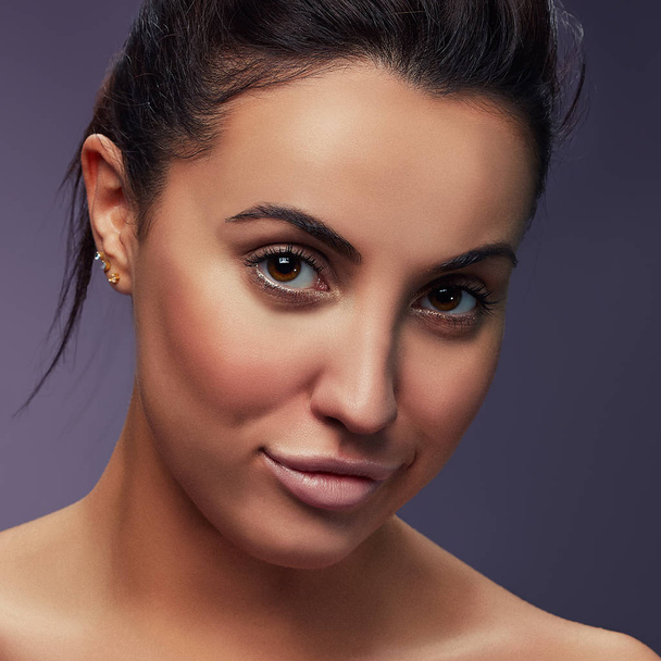Porträt einer brünetten Frau mit natürlichem Make-up auf dunklem Hintergrund  - Foto, Bild
