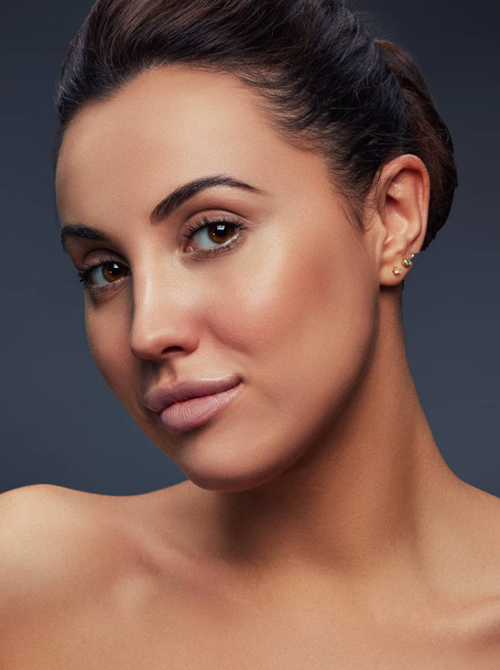 Portrait of brunette woman with natural makeup on dark background  - Photo, Image