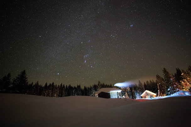 Pieni talo taustalla tähtitaivaan talvi
 - Valokuva, kuva