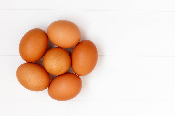 čerstvé nebo surového hnědá vejce na bílém pozadí dřevěná, pohled shora, fl - Fotografie, Obrázek