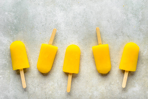 Homemade popsicles with orange juice, ice lollies on sticks, top view flat lay - Foto, immagini