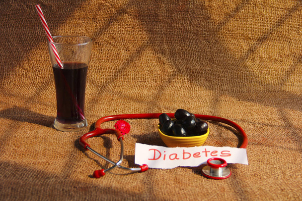 vaso de jugo Jamun, tazón de fruta Jamun o ciruela negra, estetoscopio y etiqueta de diabetes
 - Foto, imagen