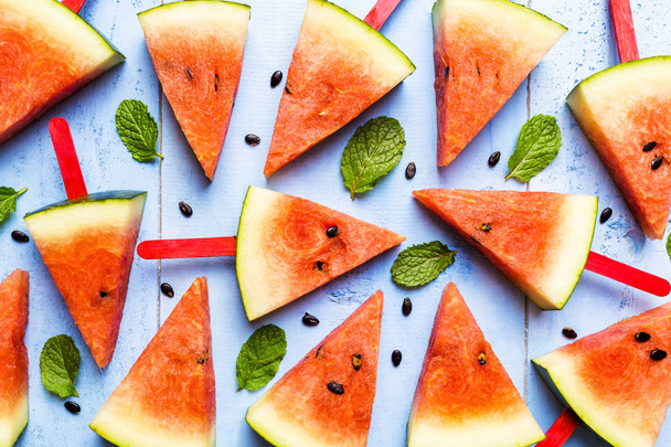 Sommer-Konzept Wassermelone Scheiben Eis am Stiel auf einem blauen rustikalen Holz  - Foto, Bild