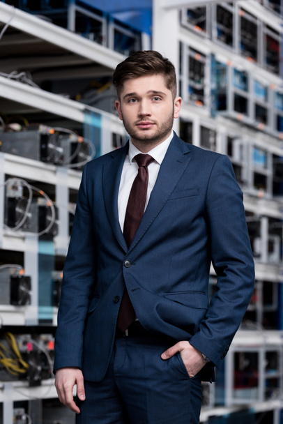 handsome young businessman in stylish suit at cryptocurrency mining farm - Photo, Image