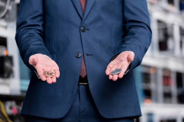 cropped shot of businessman holding bitcoins at cryptocurrency mining farm - Photo, Image