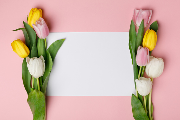 bunte Tulpen mit leerem Papier isoliert auf rosa - Foto, Bild