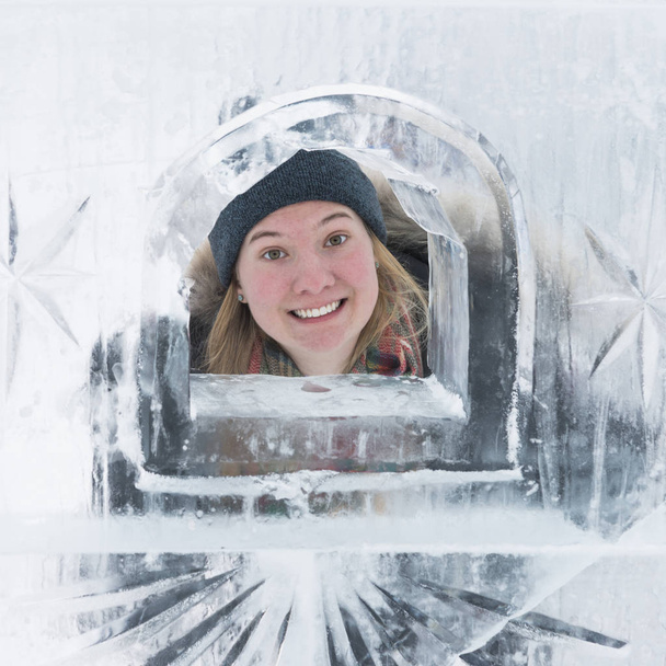 Woman looking through opening in ice castle wall, Banff National Park, Alberta, Canada - Foto, immagini