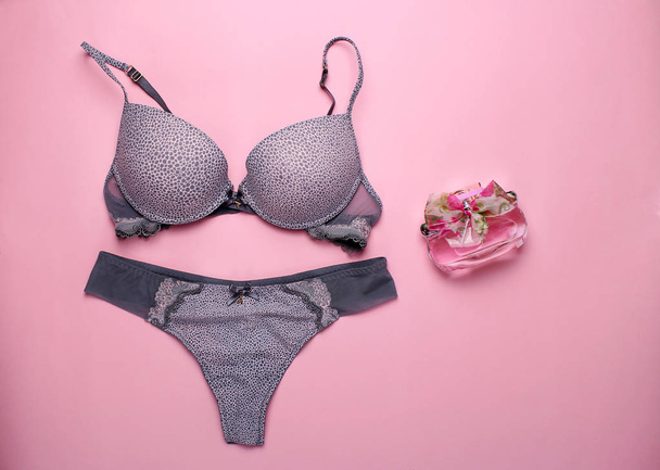 schöne weibliche Unterwäsche. Spitzenhöschen und BH liegen auf dem rosa Hintergrund. - Foto, Bild