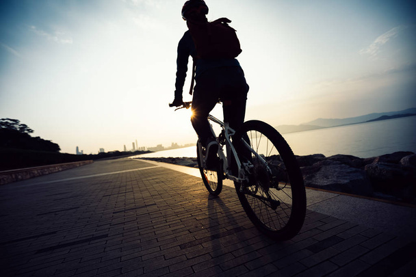 cyclist riding bike in the sunrise coast road - Foto, Imagen