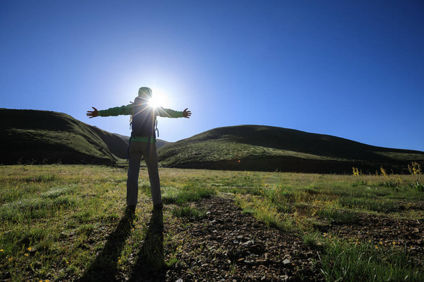 Caminhante jovem com braços abertos na montanha do nascer do sol
 - Foto, Imagem