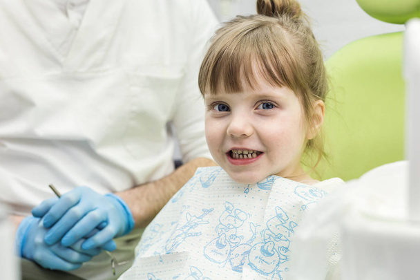 Dentist examining little girl's teeth in clinic. Dental problem. - Zdjęcie, obraz