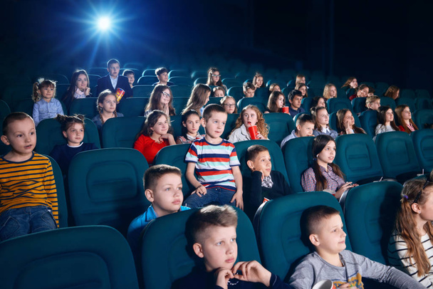 Sideview of people watching movie in the cinema hall. - Valokuva, kuva