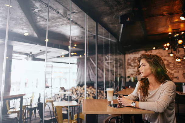 Yung kobieta siedząc w kawiarni i picia kawy. - Zdjęcie, obraz