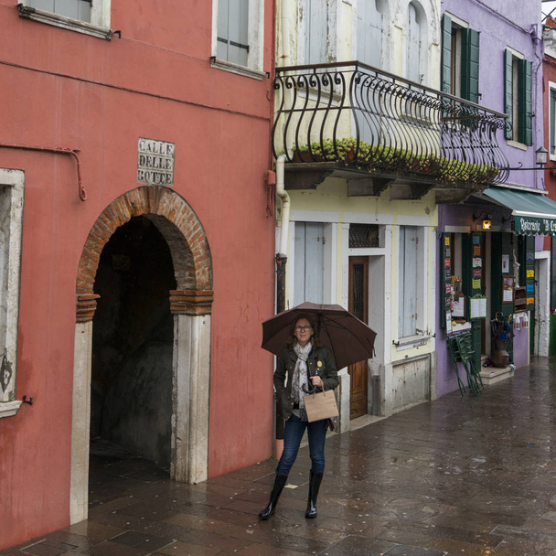 Portrait de femme debout sous un parapluie dans la rue humide pendant la pluie, Burano, Venise, Vénétie, Italie
 - Photo, image